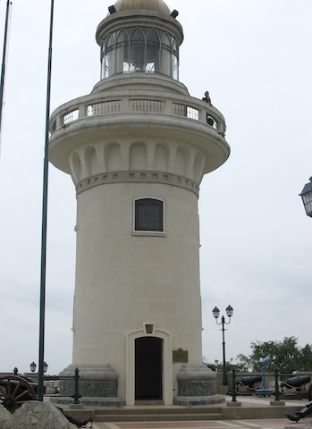 A gray lighthouse with a walkway just below the level      of the light