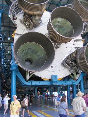 The nozzle end of the first stage of a Saturn V rocket. The scale is indicated by the people walking under it.
