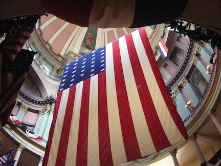A large flag hangs     down in the middle of the space. The dome and the balconies     around it are each painted in different pastel colors