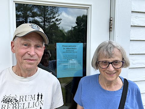We are smiling in front of the town hall door that has a blue flier              in the window